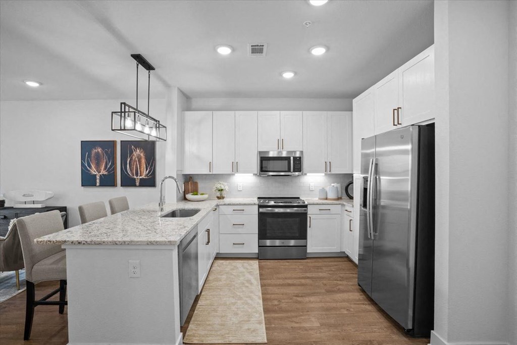 a kitchen with stainless steel appliances and a marble counter top