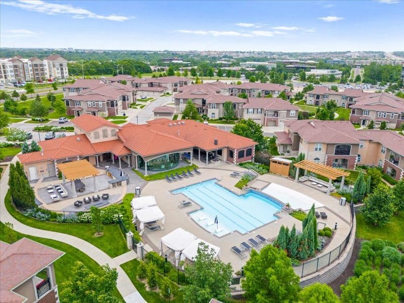 an aerial view of a swimming pool in a neighborhood with houses