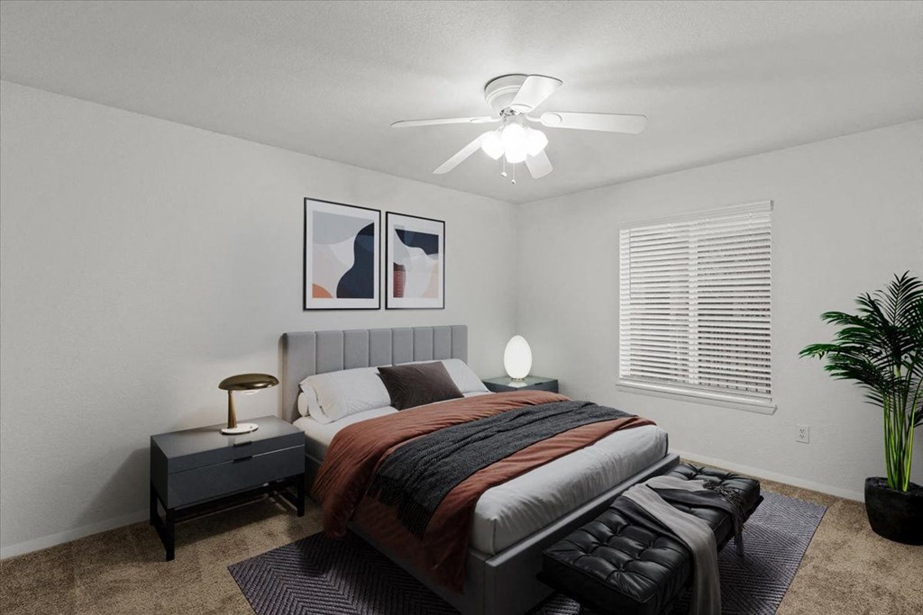 a bedroom with a bed and a ceiling fan