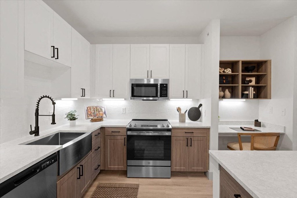 a kitchen with white cabinets and a stove and a microwave