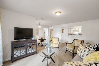 a living room with couches and chairs and a flat screen tv at Stonebriar Woods, Overland Park
