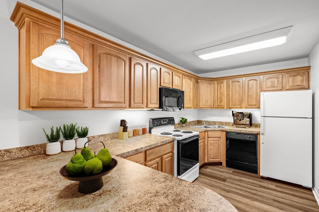 a kitchen with wooden cabinets and a granite counter top at Malvern Hill Apartment Homes, 66103 66214