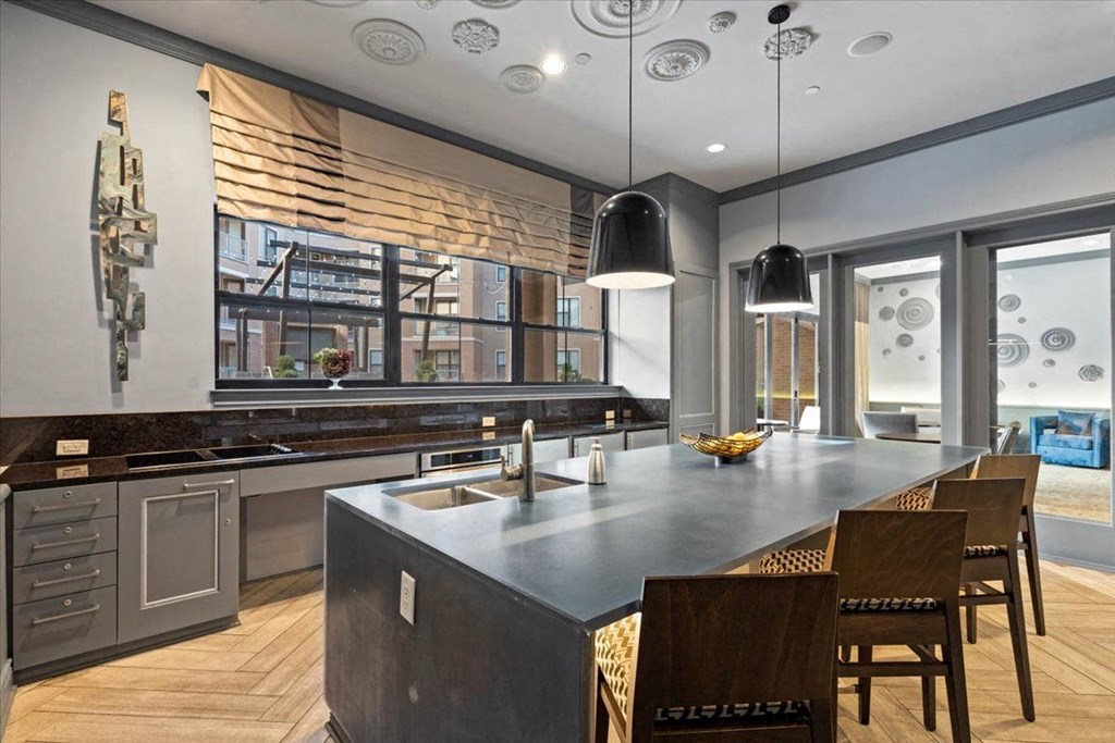 the kitchen has a large island and stainless steel appliances