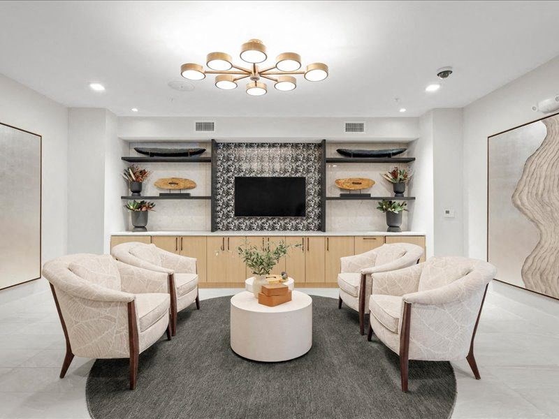 a dining room with white chairs and a table and a television