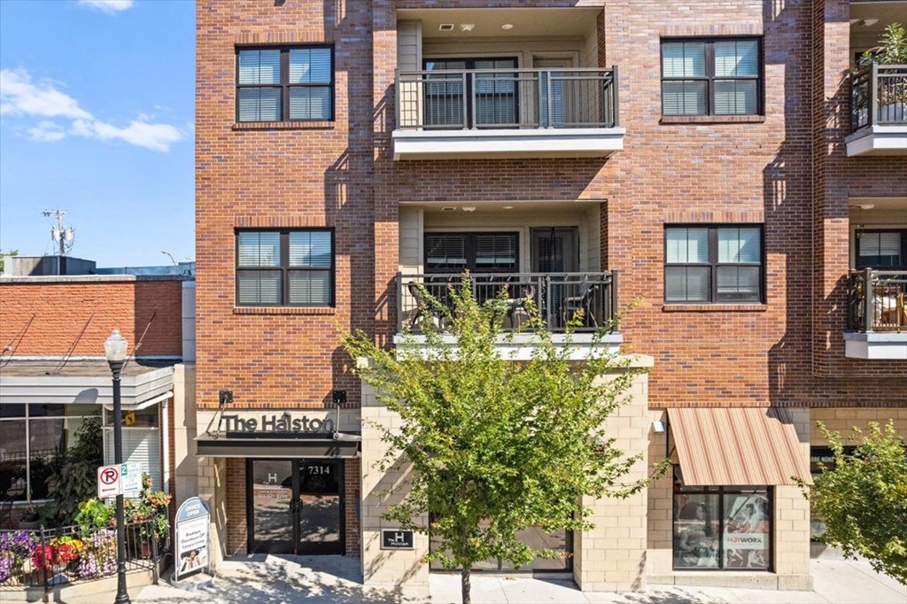 a brick apartment building with a tree in front of it