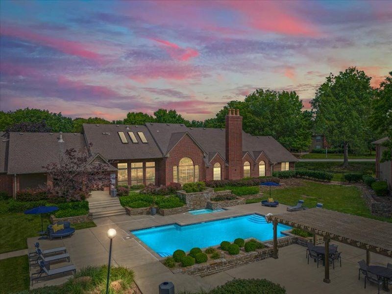 a backyard with a swimming pool and a house at Highland Park Apartment Homes, Overland Park