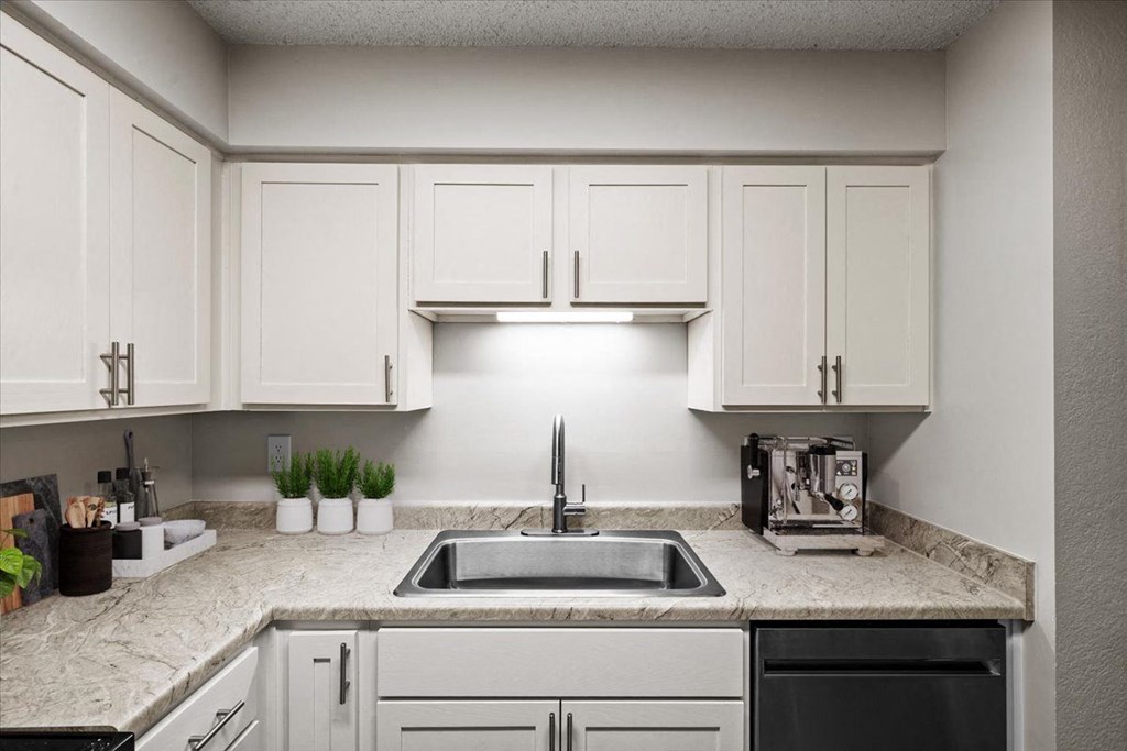 A kitchen with a sink and a coffee maker at Cloverset Active Adult Apartments, Kansas City, MO