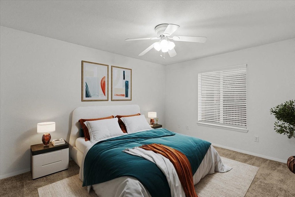 a bedroom with a bed and a ceiling fan