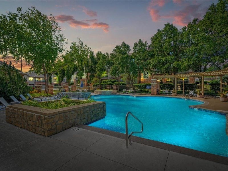 a large swimming pool with trees around it