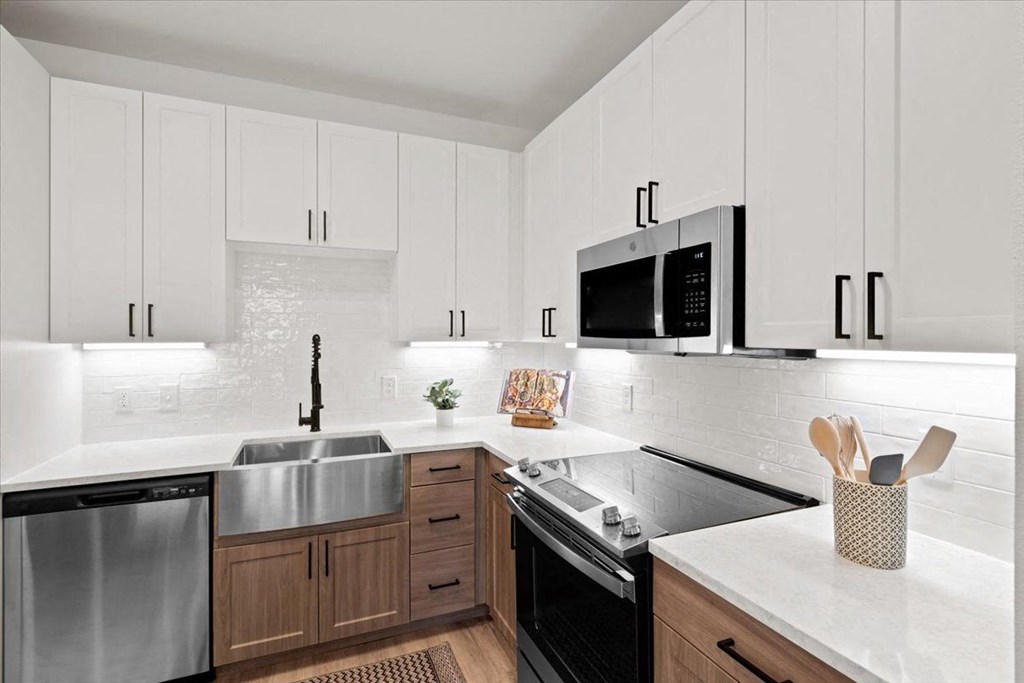 a kitchen with white cabinets and stainless steel appliances