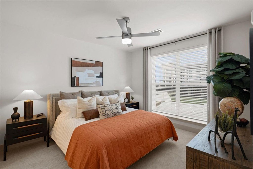a bedroom with a bed and a ceiling fan
