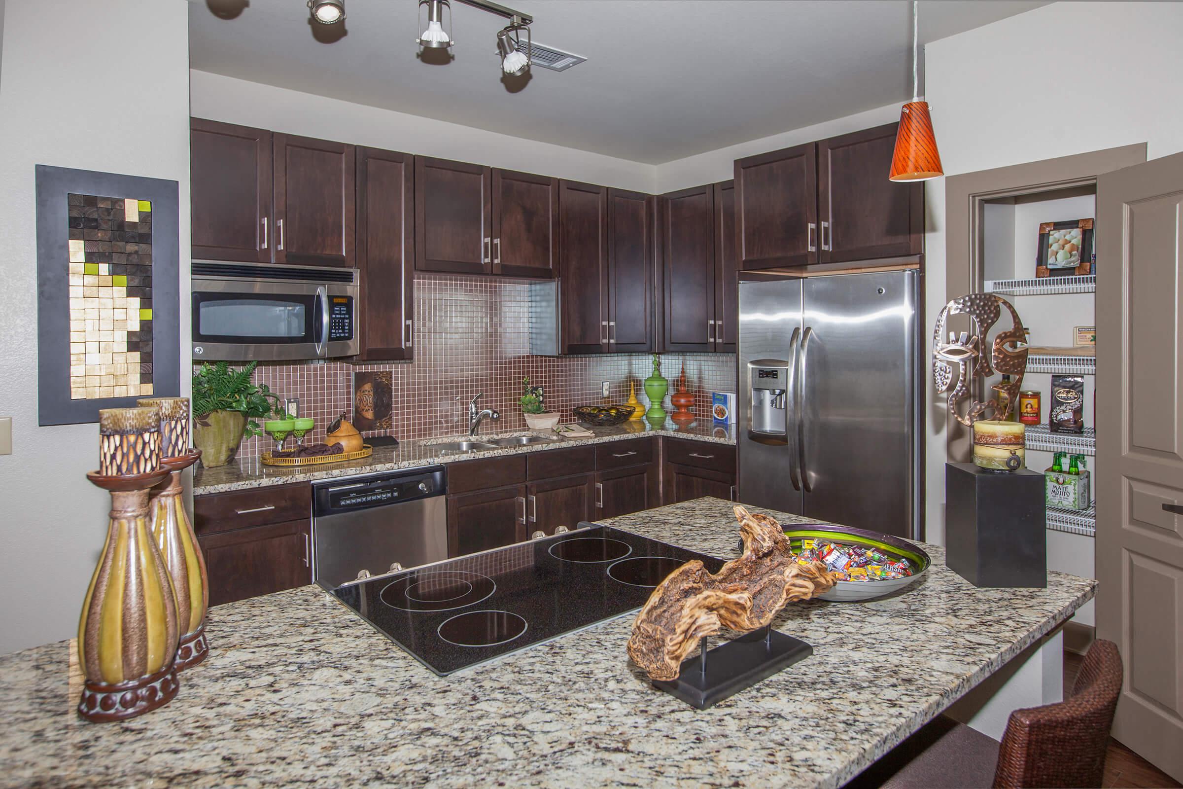 a kitchen with dark wood cabinets and granite countertops