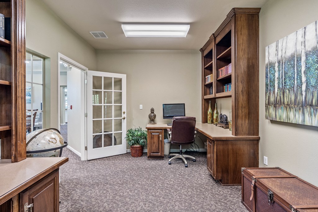 an office with a computer and a bookshelf