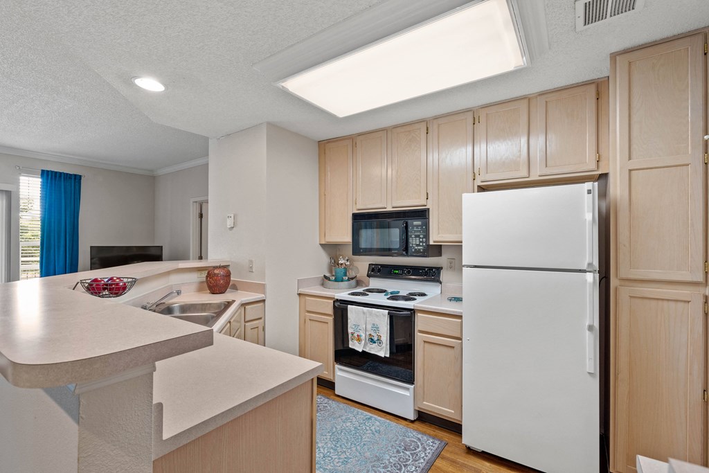 a kitchen with a white refrigerator freezer next to a stove top oven  at Claremont, Overland Park, KS