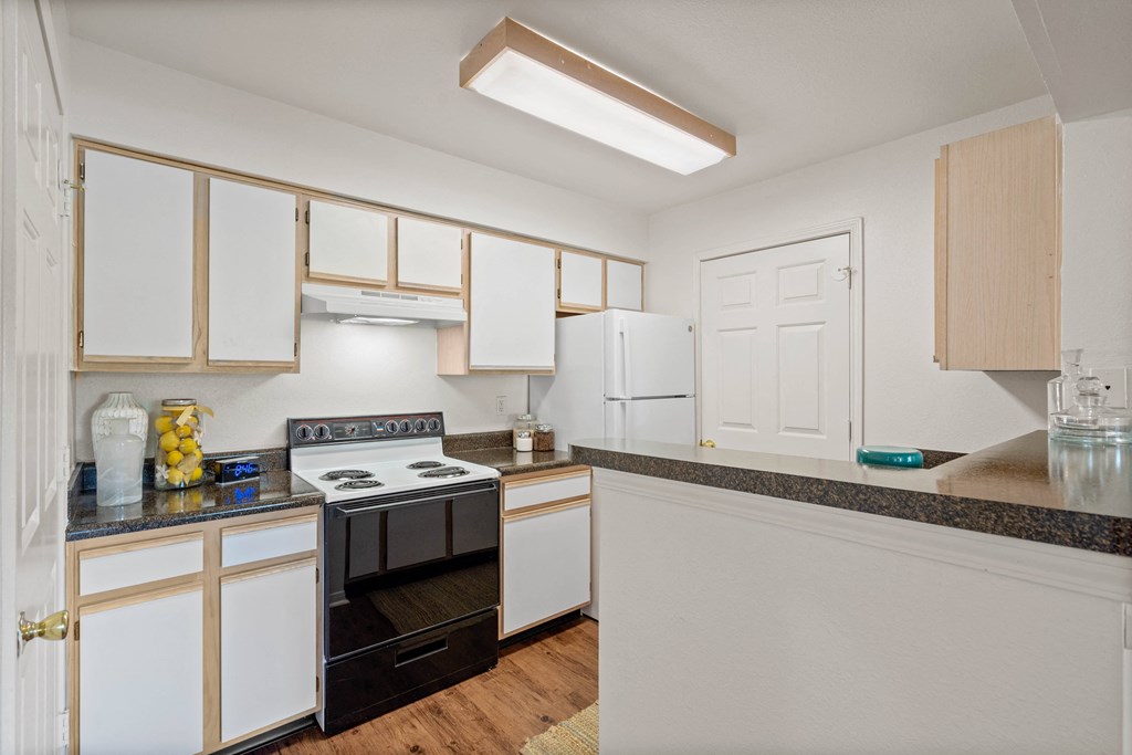 a kitchen with white cabinets and black appliances