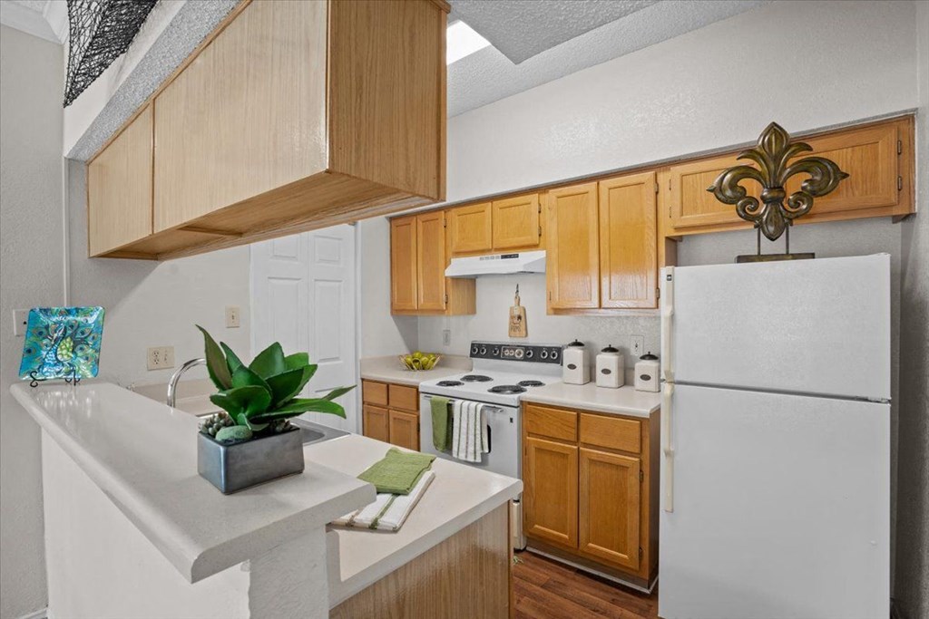 a kitchen with a white refrigerator freezer next to a stove top oven at Creekview Apartment Homes, Texas, 75254