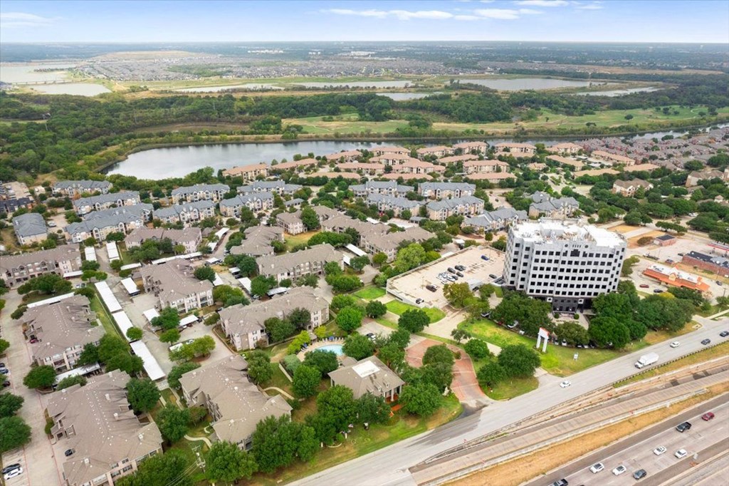 an aerial view of a city with a lake in the background at The Clairborne Apartment Homes, Grand Prairie, TX