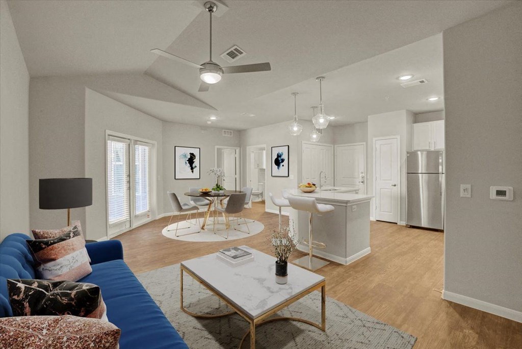 a living room and kitchen with a couch and a table