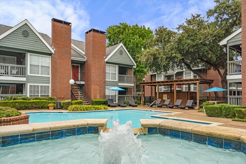 a swimming pool with a fountain in front of a building at Pear Ridge, Dallas