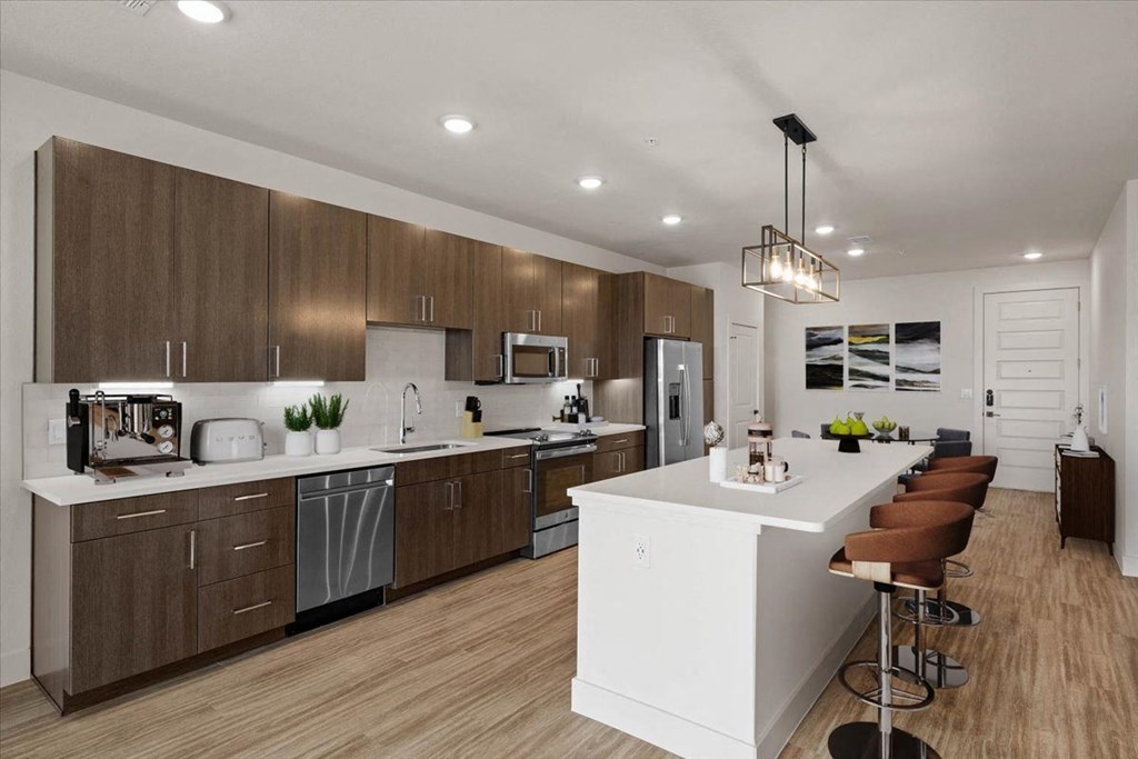 a large kitchen with a white island and wooden cabinets