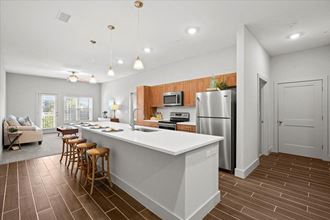 a kitchen with a white counter top next to a living room