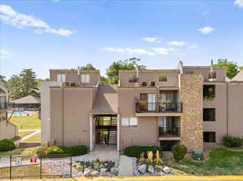 A modern apartment complex with a pool in the backyard.