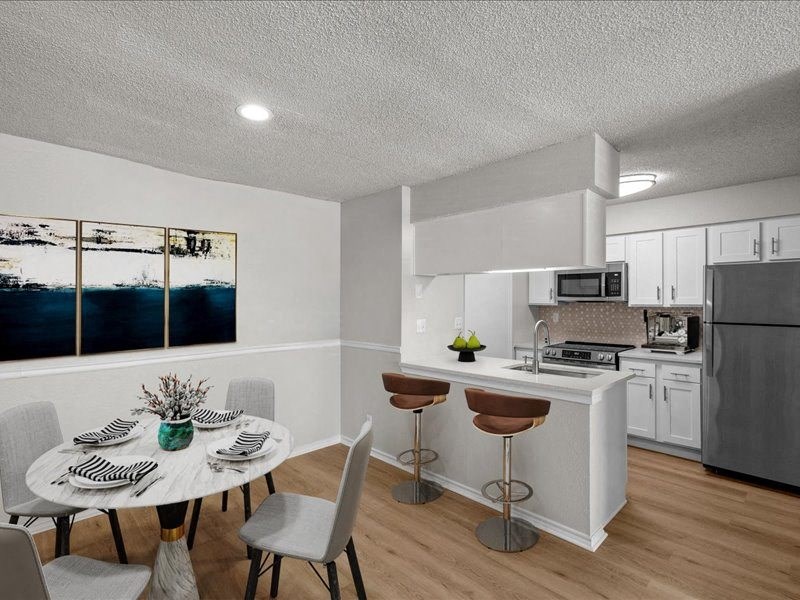a kitchen and dining room with a table and chairs at Highland Park Apartment Homes, Overland Park