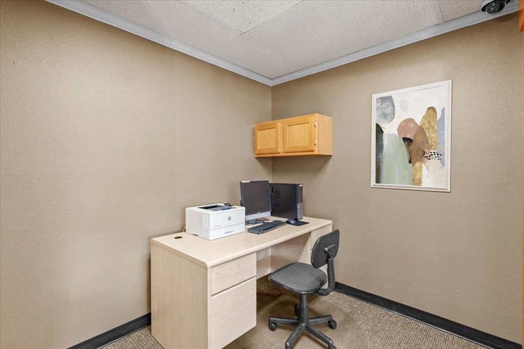 a desk with a computer and a printer in a room
