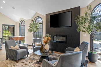A living room with grey chairs and a black television.