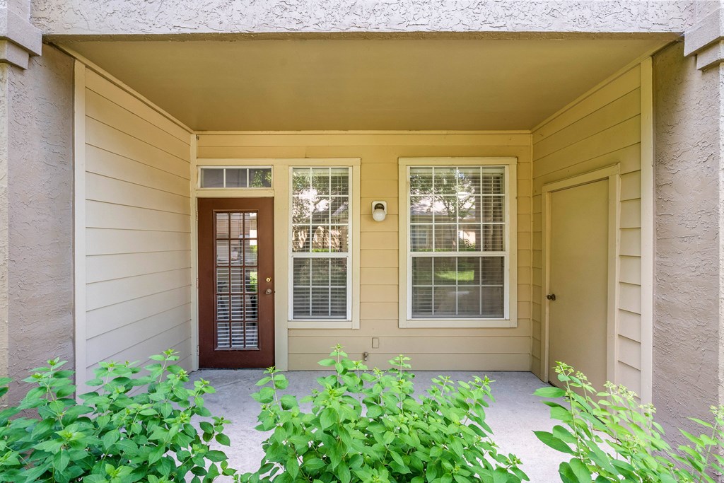a front porch with a door and windows