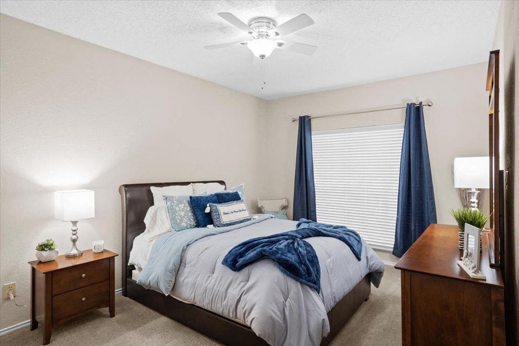 a bedroom with a bed and two night stands at Creekview Apartment Homes, Texas