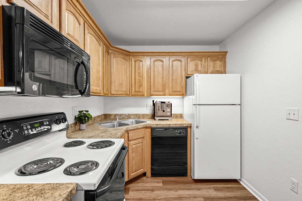 a kitchen with wooden cabinets and white appliances at Malvern Hill Apartment Homes, Kansas, 66214