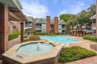 the preserve at ballantyne commons community pool and hot tub with apartment buildings in the backgroundat Pear Ridge, Dallas, 75287 - Photo Gallery 3