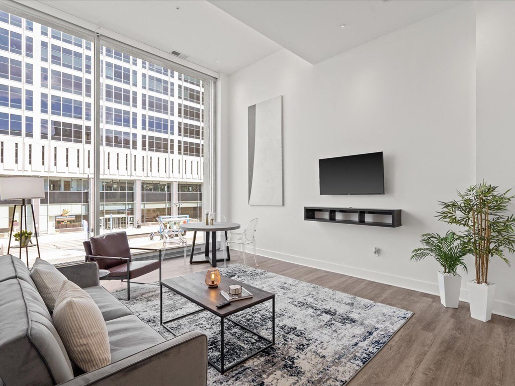 a living room with a large window and a couch at Sky On Main Apartments, Missouri City, MO, 64105