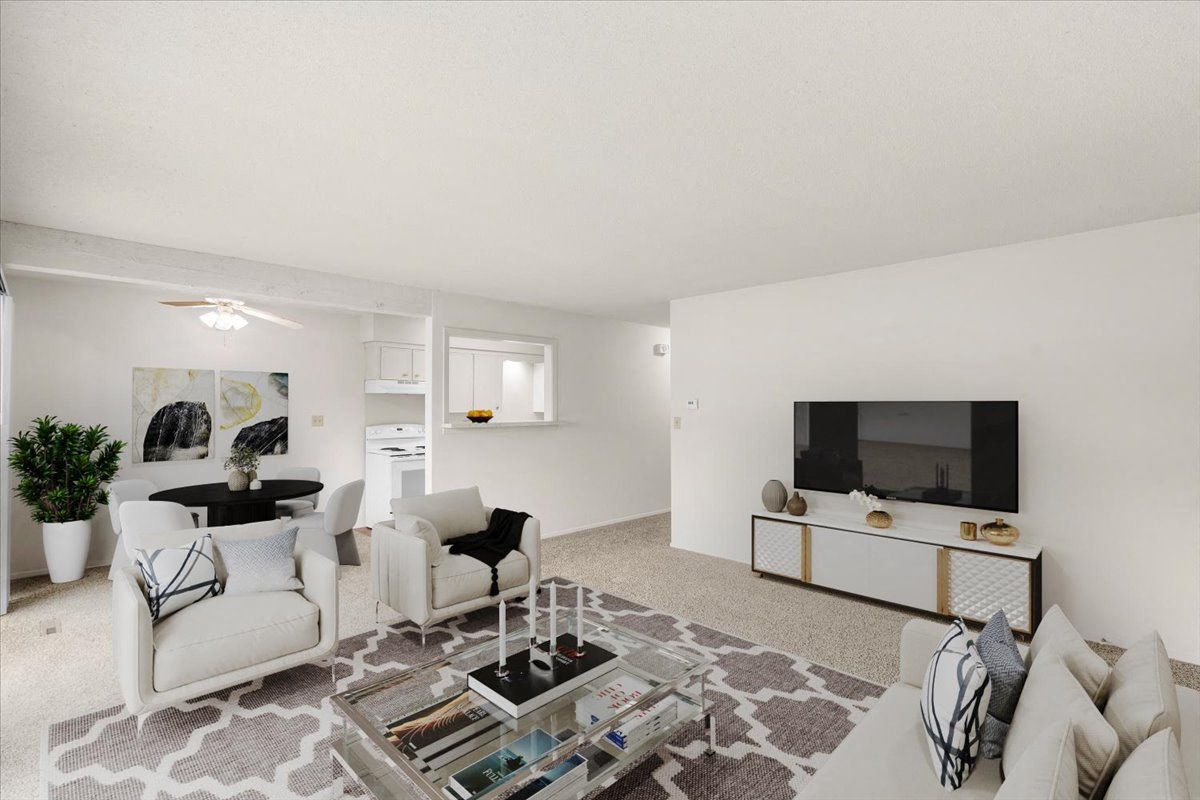 a living room with white furniture and a television