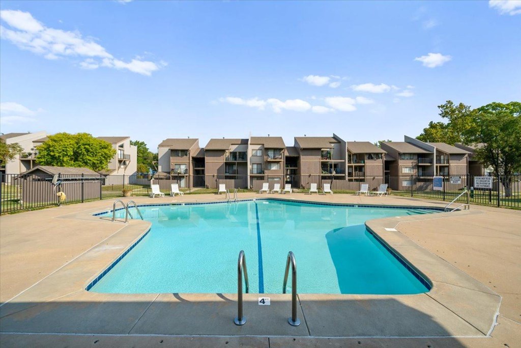 A swimming pool in front of apartment buildings.