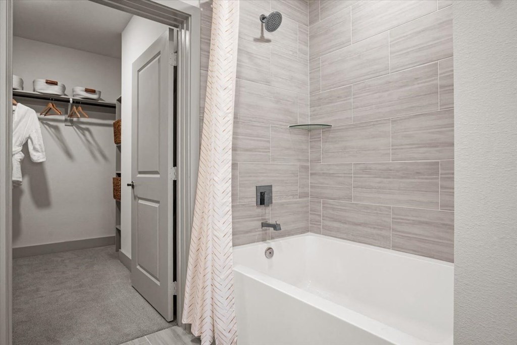 a bathroom with a tub and a shower and a closet