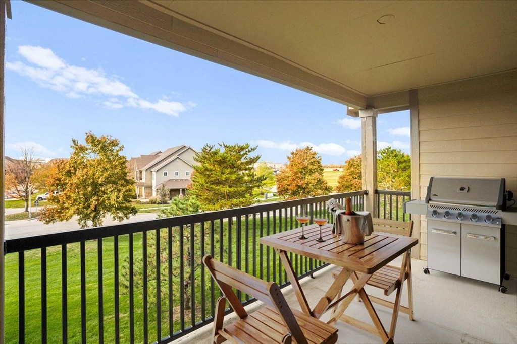 a patio with a table and chairs and a grill