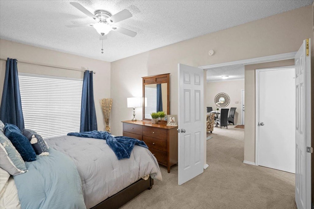 a bedroom with a bed and a ceiling fan at Creekview Apartment Homes, Texas
