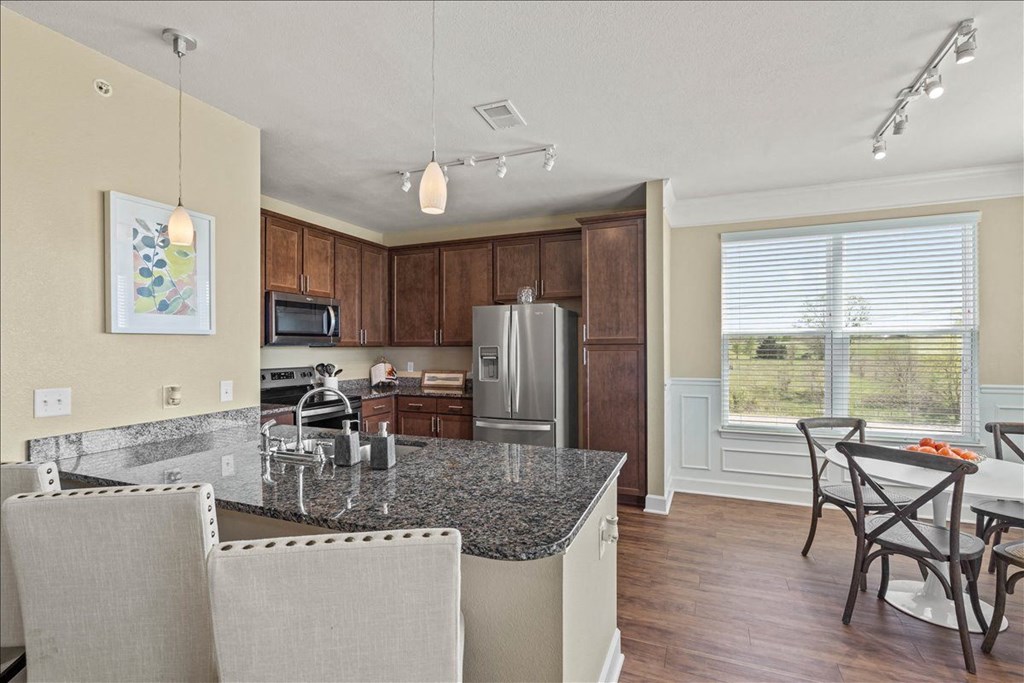 a kitchen with a granite counter top and a table with chairs