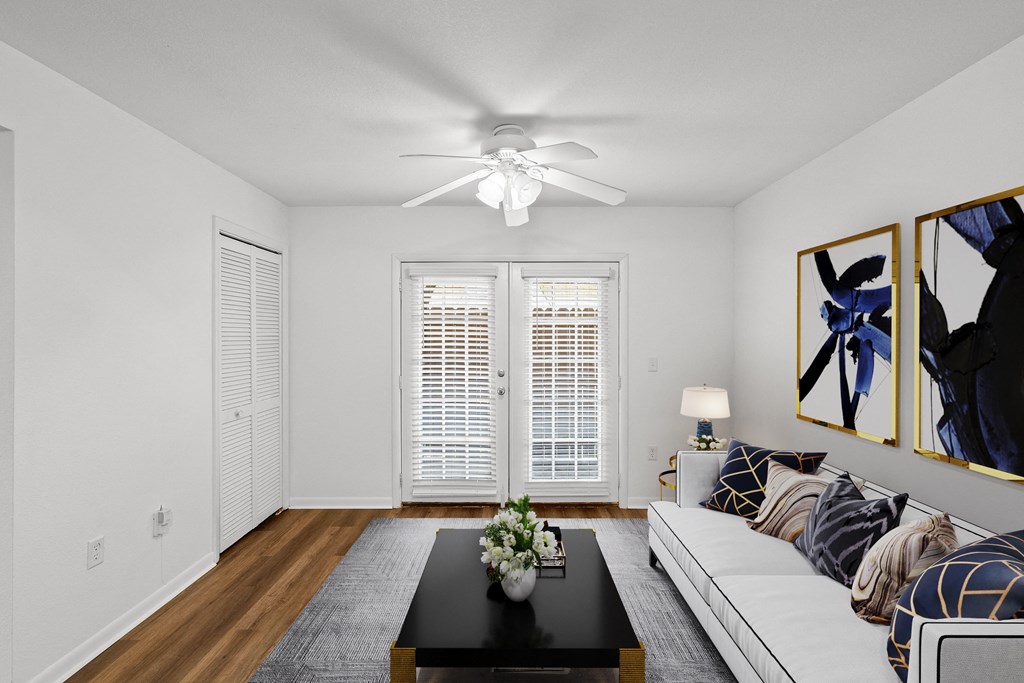 a living room with white walls and hardwood floors at Malvern Hill Apartment Homes, Kansas