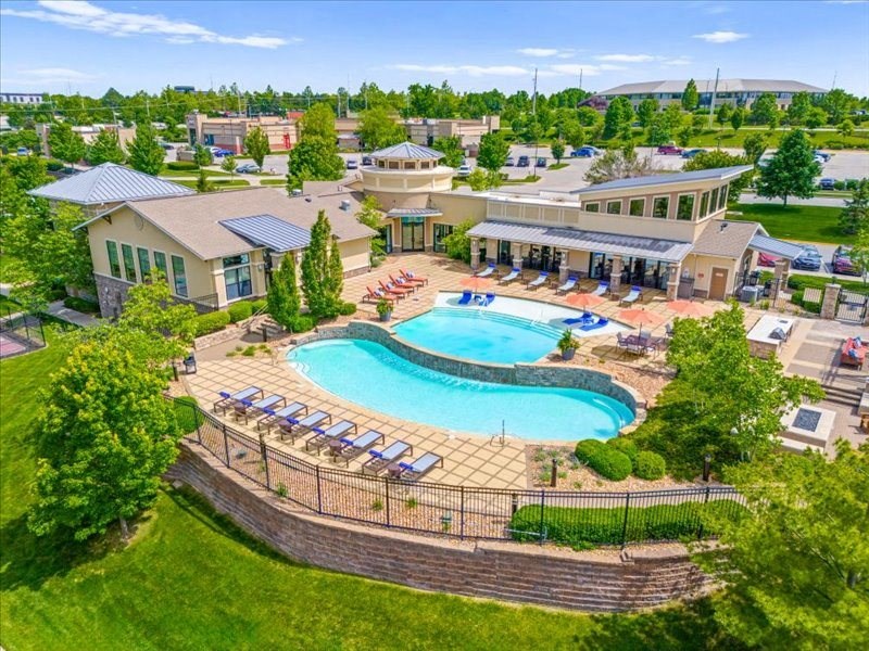 an aerial view of a resort style pool with lounge chairs