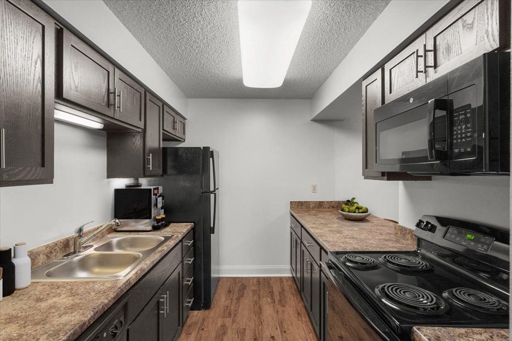 a kitchen with black appliances and counter tops and