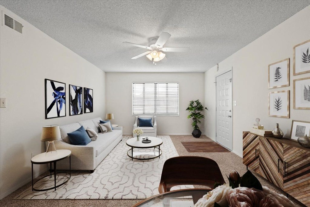 A living room with a window and a ceiling fan.