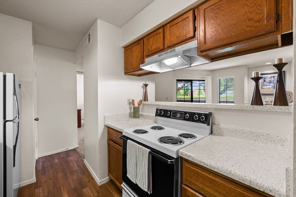 A kitchen with a stove top oven and a refrigerator. at Coventry Oaks Apartments, Overland Park, KS, 66214