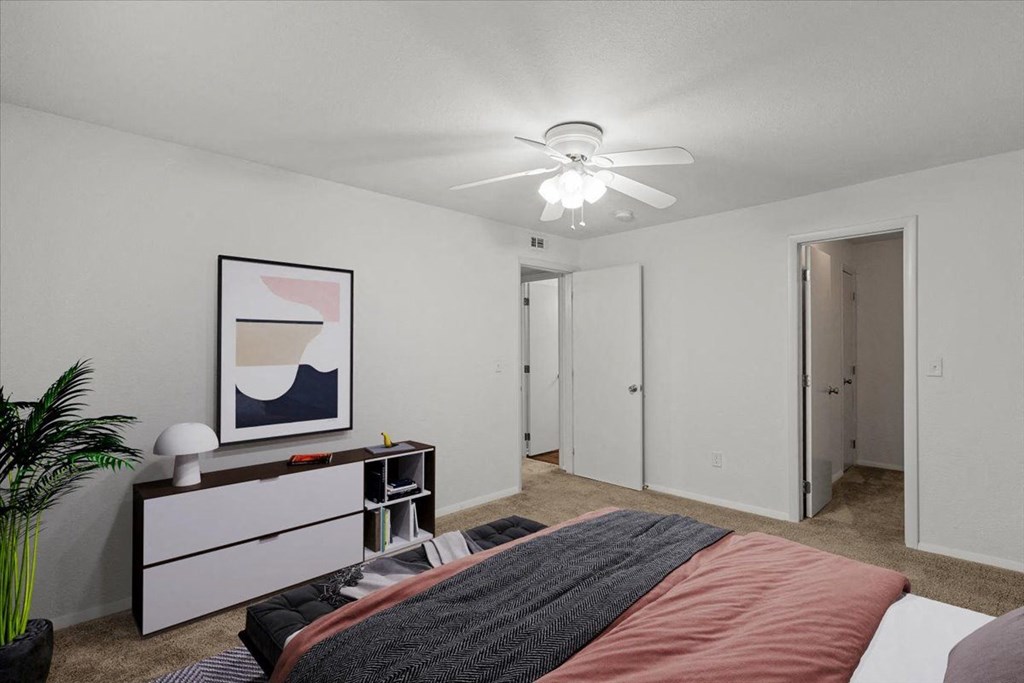 a bedroom with a bed and a ceiling fan