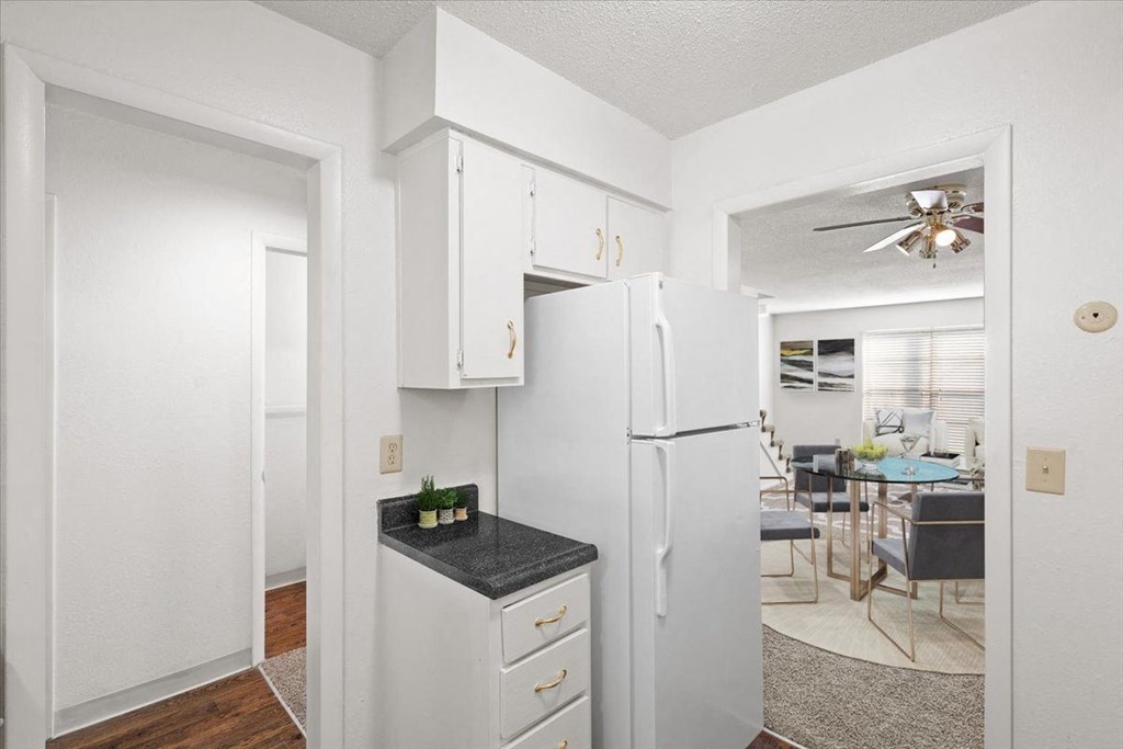 a kitchen with white cabinets and a white refrigerator