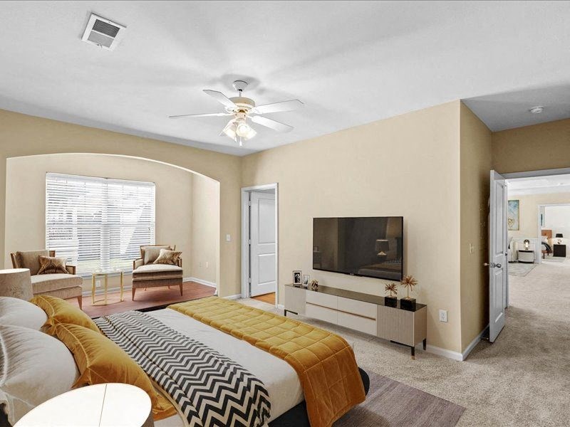 a living room with a bed and a ceiling fan