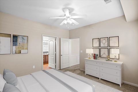 a bedroom with a white bed and a ceiling fan
