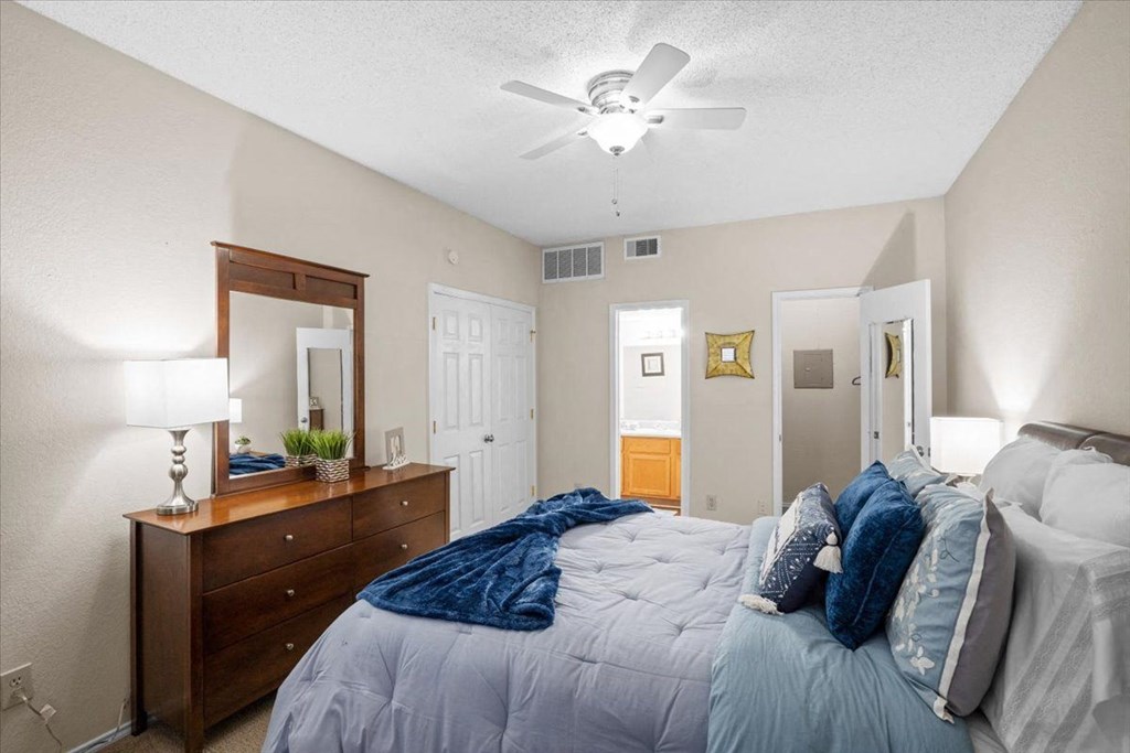 a bedroom with a bed and a ceiling fan at Creekview Apartment Homes, Dallas, 75254